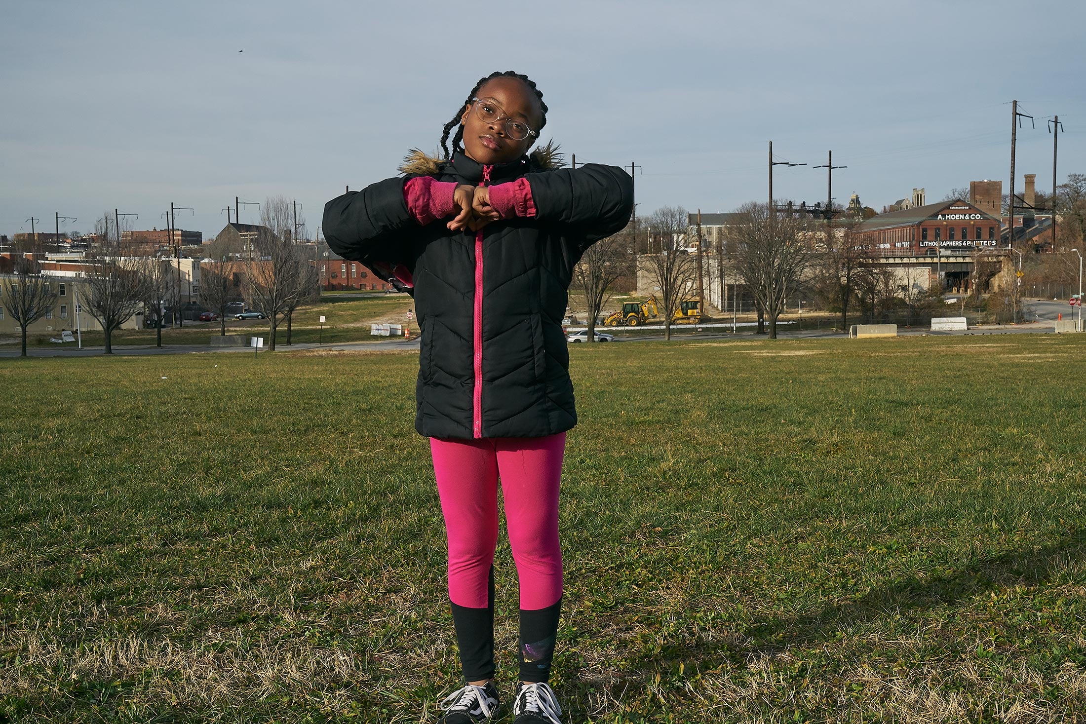 Kareena, standing in a field of grass pressing her hands together, fifth grade.