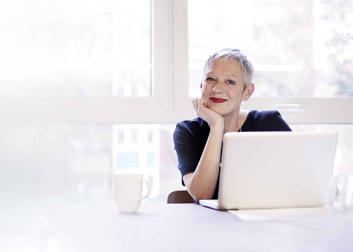 Woman working on laptop, smiling.
