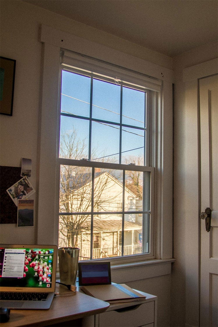 Laptop on a desk next to a window