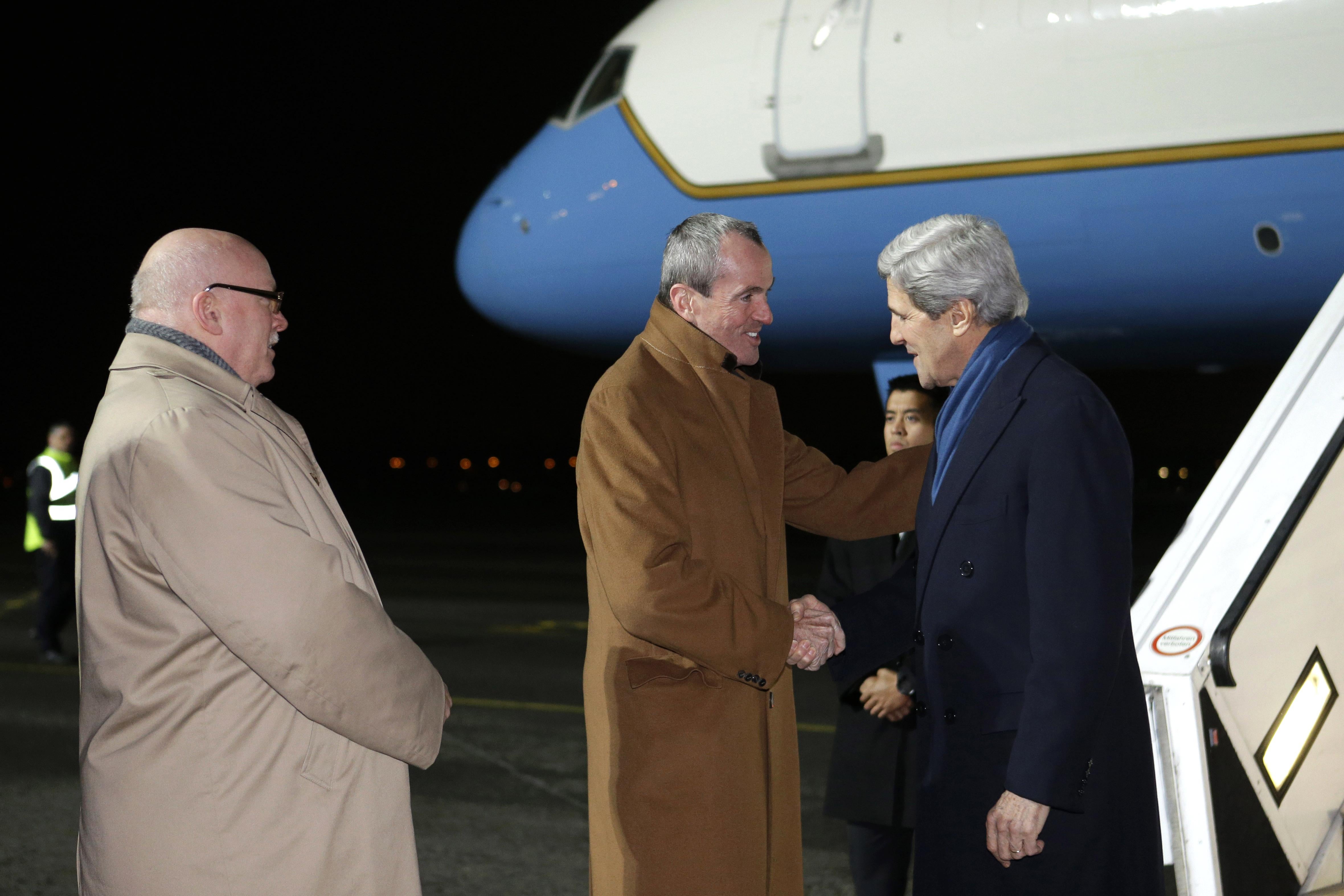 Deputy Chief of Mission US Embassy in Berlin, James Melville (L) and US Ambassador Philip D Murphy (C) welcome US Secretary of State John Kerry (R) as he arrives at the Tegel Airport in Berlin on February 25, 2013.