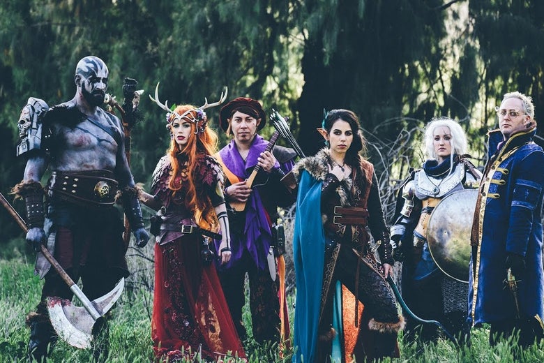Six people in fantasy costumes stand in a field