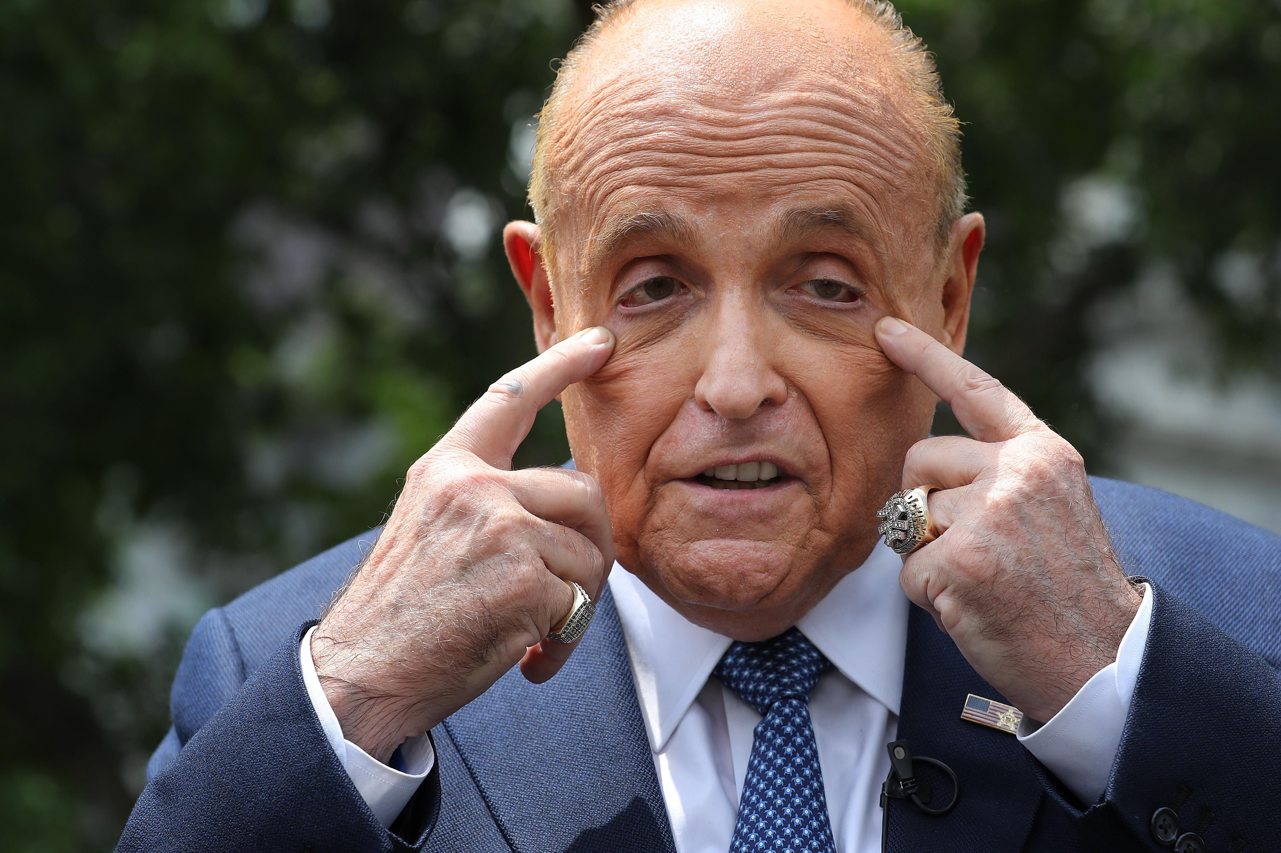 Former New York City Mayor Rudy Giuliani pulling at his eyes with his hands as he talks to journalists outside the White House West Wing July 01, 2020 in Washington, DC.