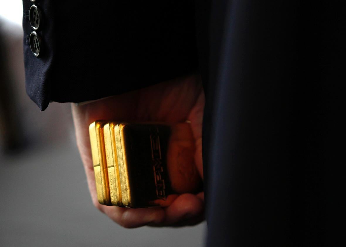 Developer Donald Trump holds three bars of Gold Bullion after accepting it as a security deposit from the American Precious Metals Exchange for a 10 year lease for APMEX on the 50th floor of 40 Wall Street in New York City, a Trump owned property, during a news conference in New York, September 15, 2011.   