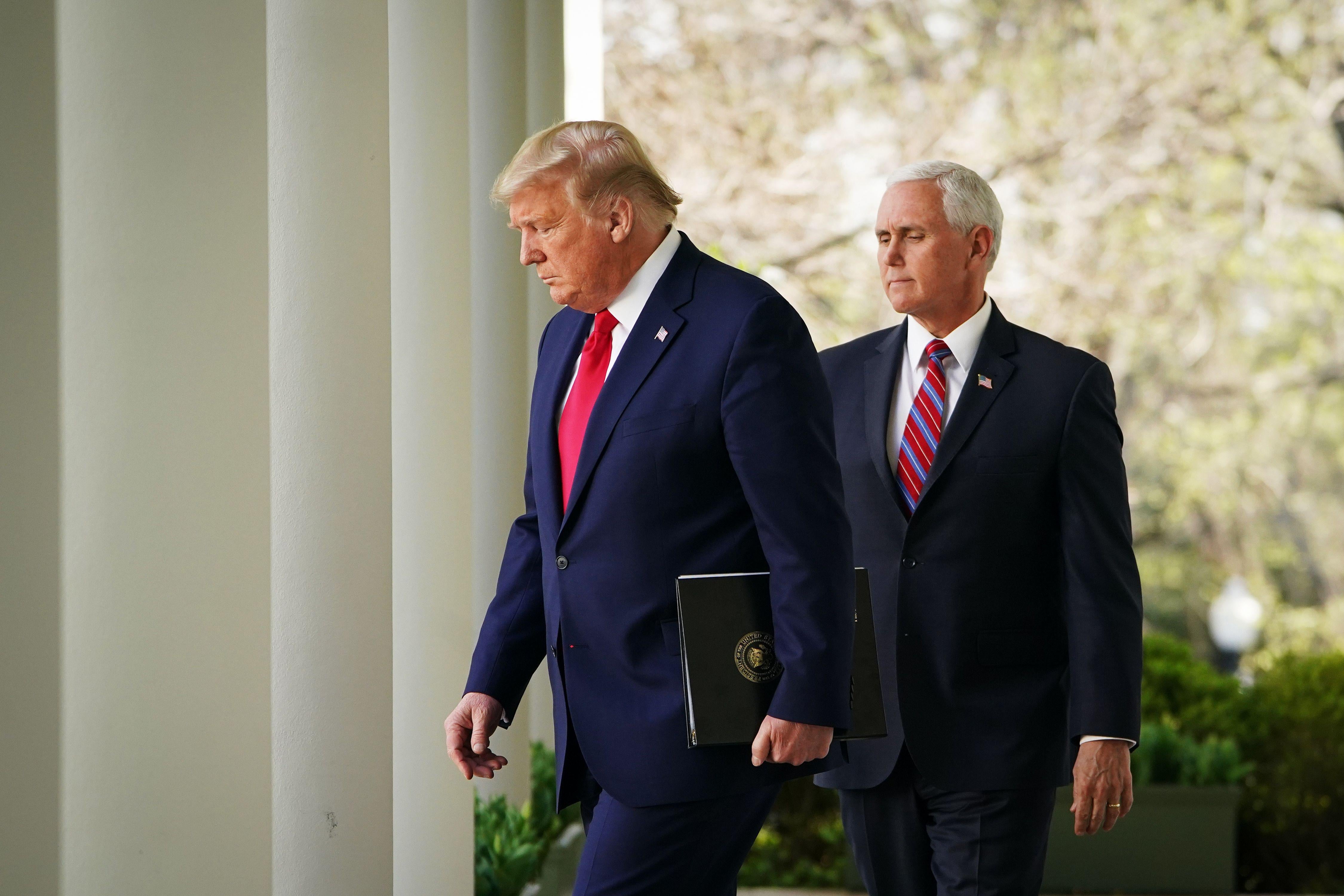 Donald Trump and Mike Pence walk through the colonnade of the White House on Monday.