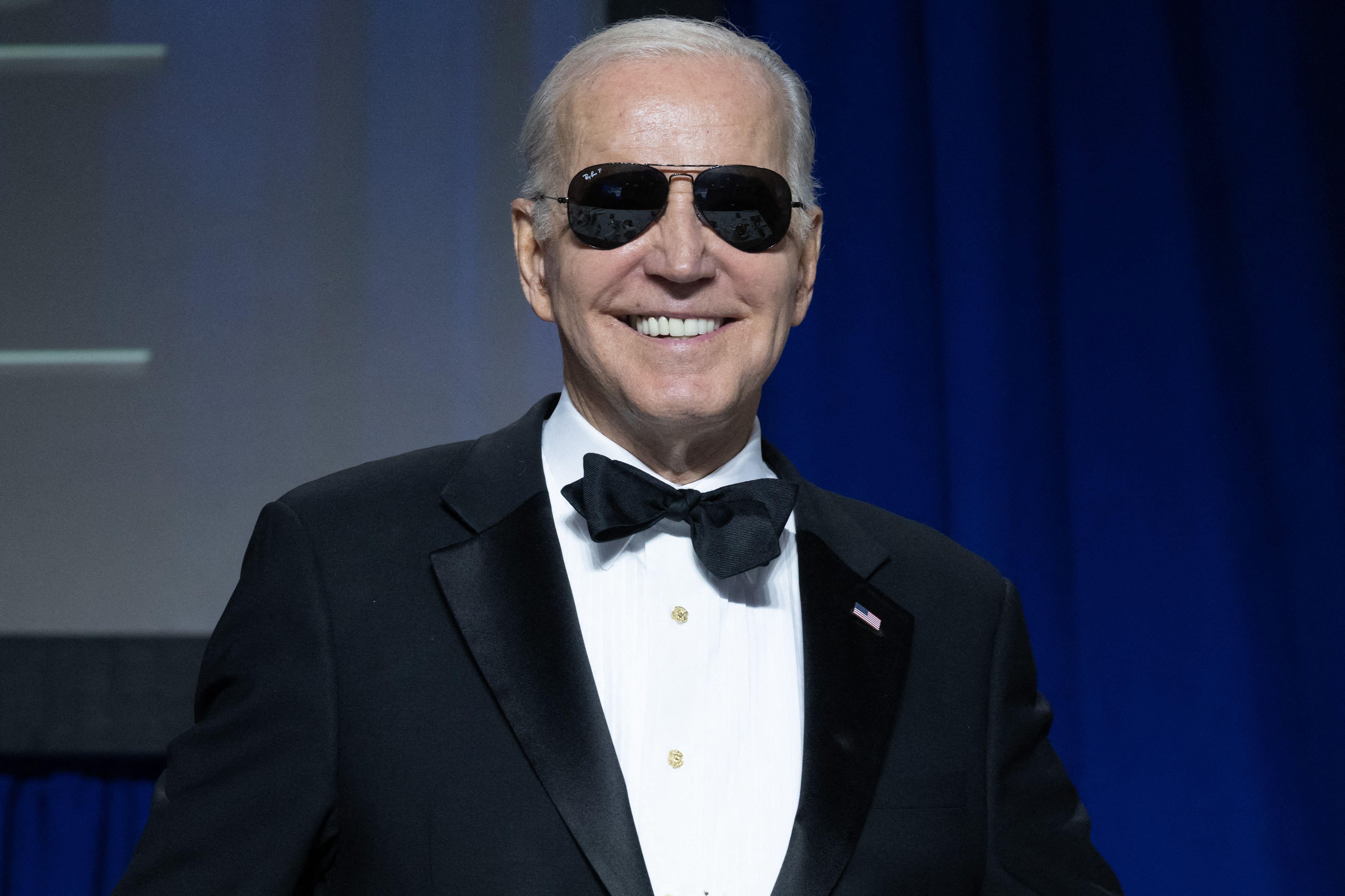 President Joe Biden smiles while wearing sunglasses.