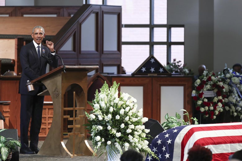 Obama stands at a podium with Lewis' American flag–draped casket just visible in the foreground.