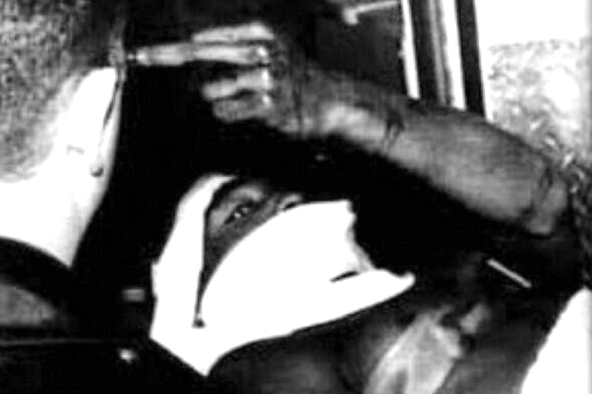 Tupac gives the middle finger while laying on a stretcher.