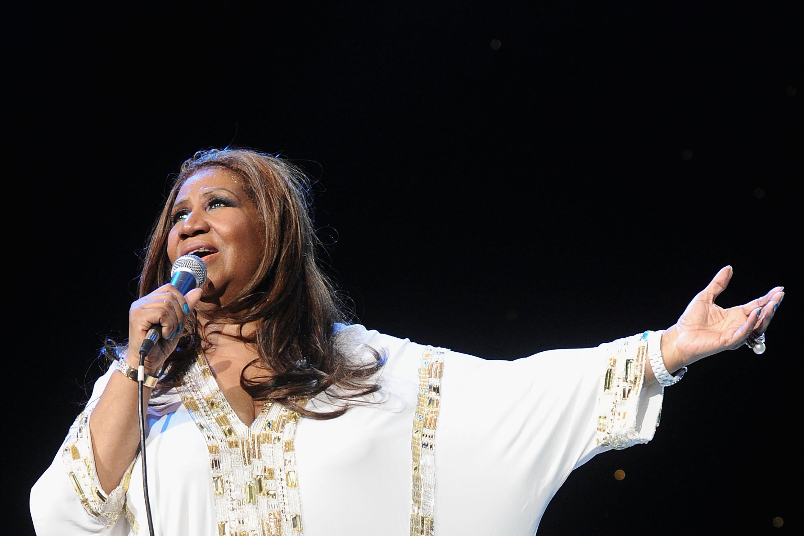 Aretha Franklin at Radio City Music Hall, arm outstretched.