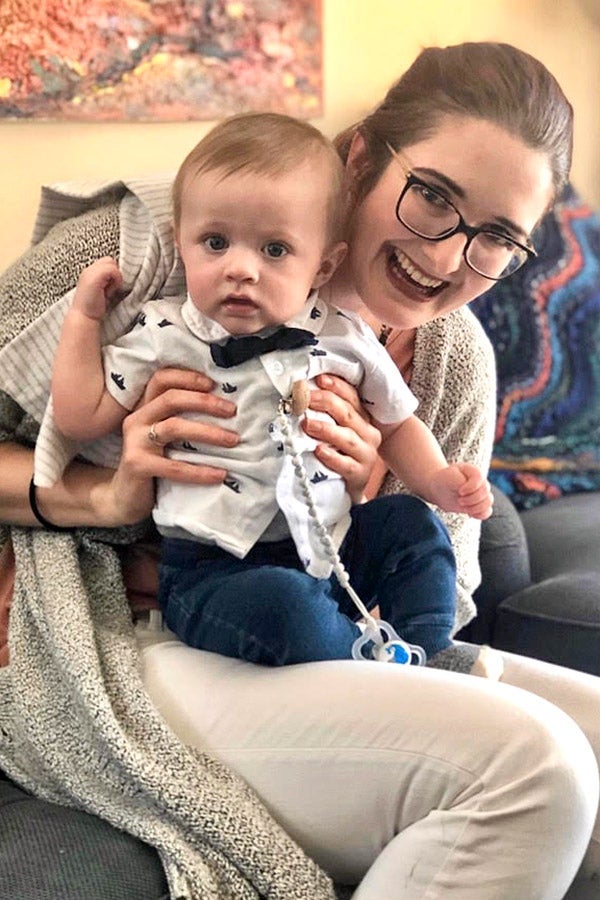 A woman holds a baby in her lap.
