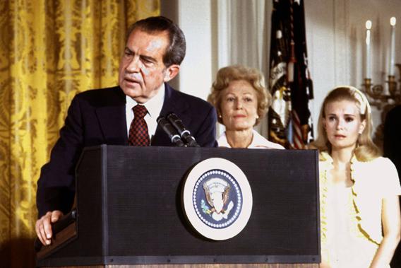 U.S. President Richard Nixon listened to by First lady Pat Nixon and daughter Tricia Nixon (R), says goodbye to family and staff in the White House East Room on August 9, 1974.
