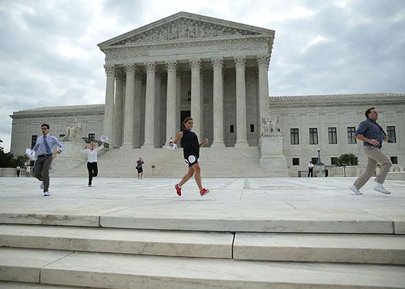 News interns run out with the ruling regarding same-sex marriage from the U.S. Supreme Court June 26, 2015 in Washington, DC.