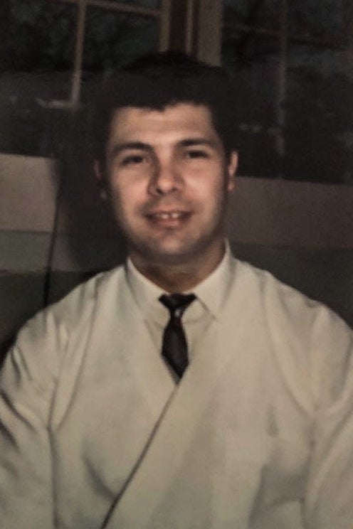 Pasquale looking at the camera in a white jacket