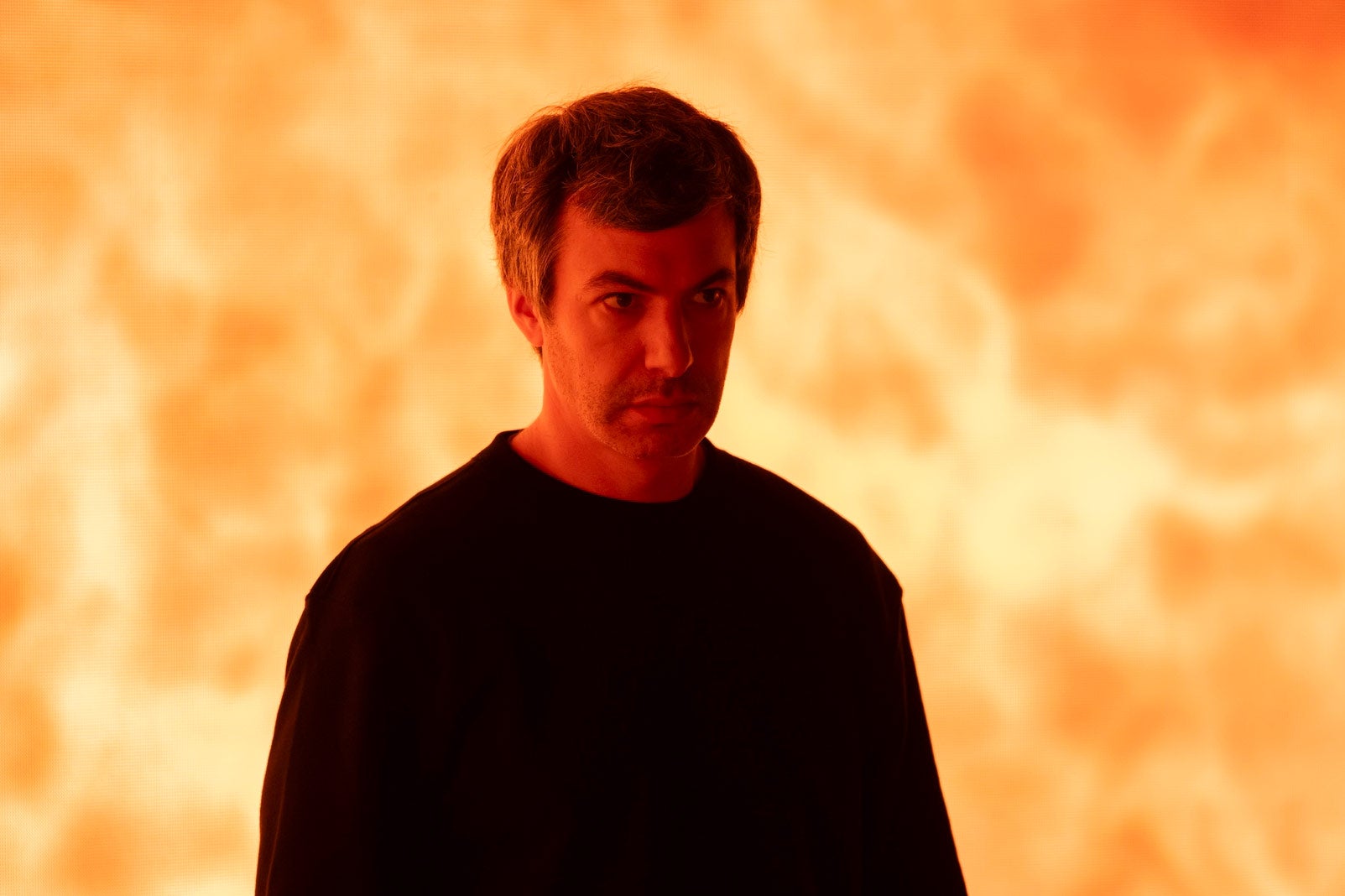 Nathan Fiedler in front of a wall of flames