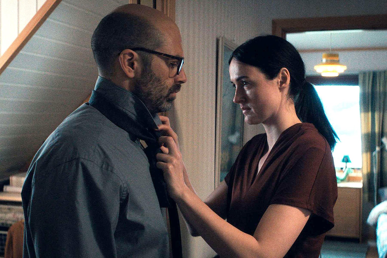 A woman helps a man adjust his tie.