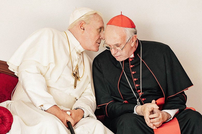 Anthony Hopkins whispers in Jonathan Pryce’s ear in The Two Popes.