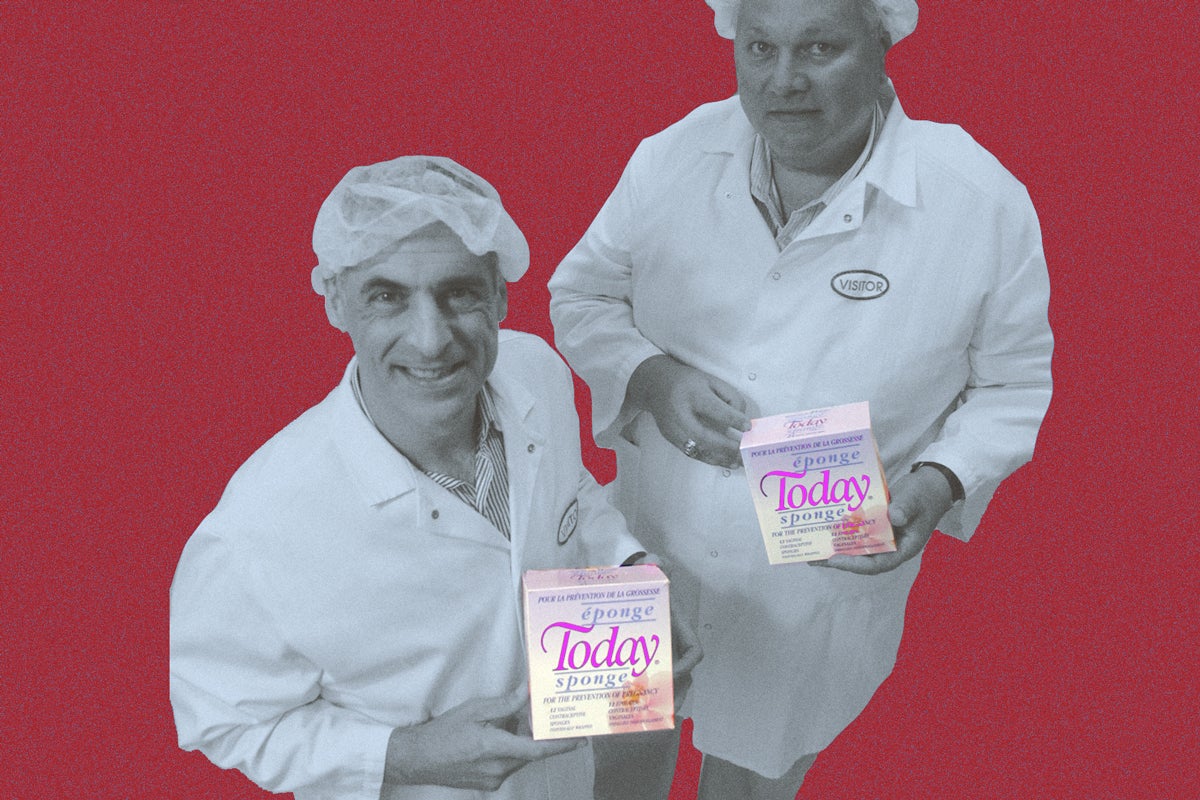 Two people in hairnets and white lab coats posing with boxes that say "Today" on them in purple-pink swooping letters
. 