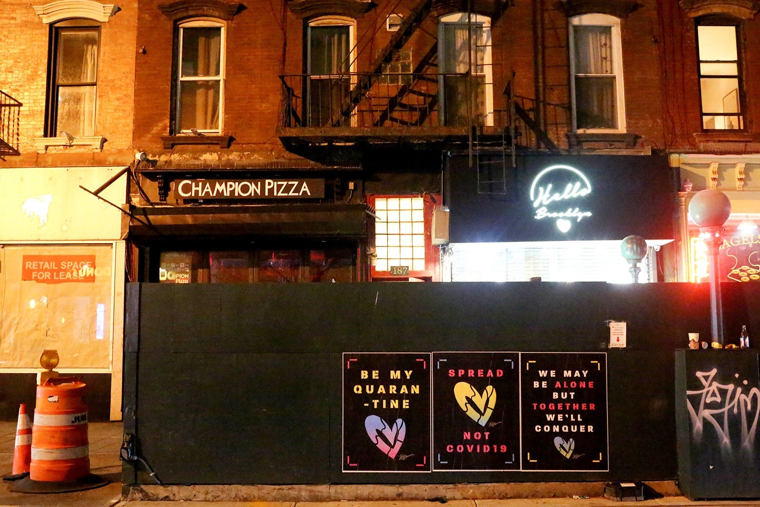 Posters on a Williamsburg street read "Be my quarantine," "Spread love not COVID-19," and "We may be alone but together we'll conquer."