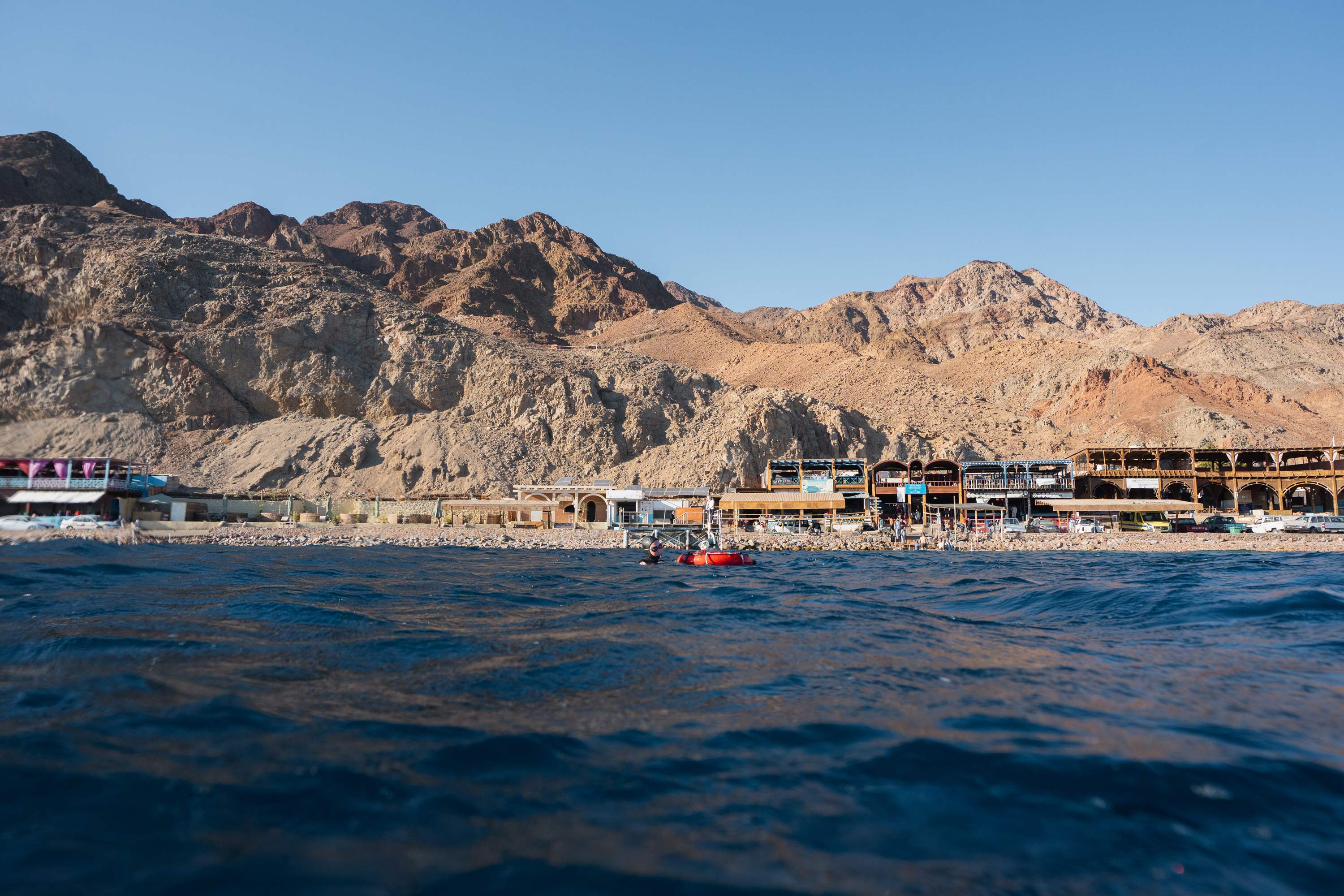 A sandy, hilly beach as seen from out on the water.