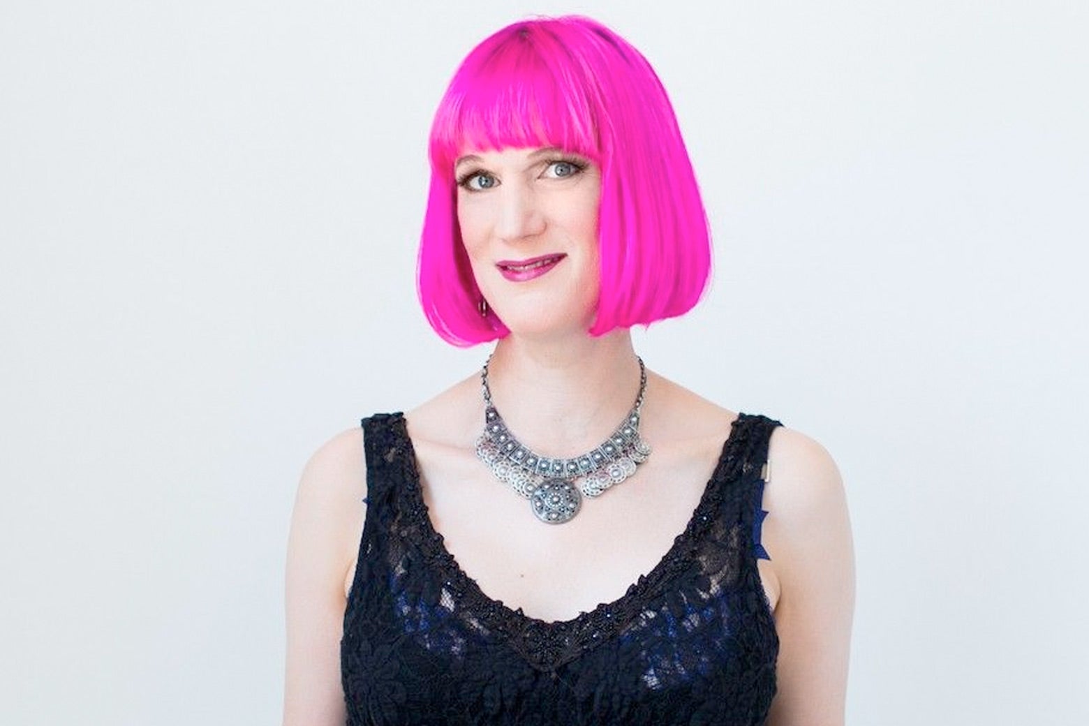 A white woman with a bright pink bob dressed in a formal gown.