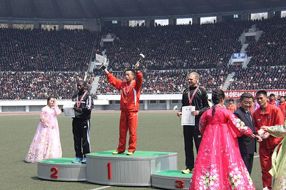 The winner celebrates his victory inside Kim Il-Sung Stadium. The men's race was won by a local Korean for the first time in several years.