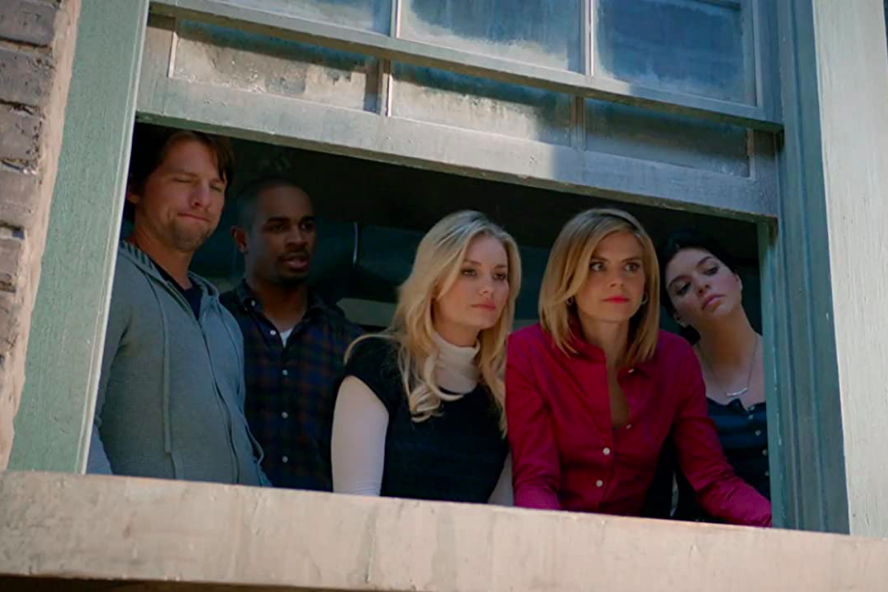 Elisha Cuthbert, Zachary Knighton, Damon Wayans Jr., Casey Wilson, and Eliza Coupe look through a window.