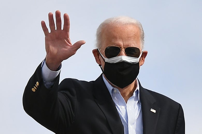 Biden waves, wearing sunglasses and two masks