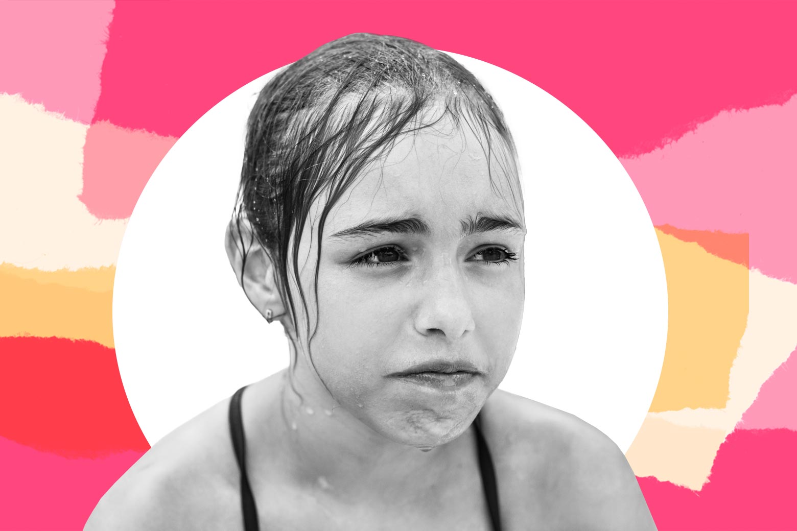 A young girl, having just gone swimming, looks upset.