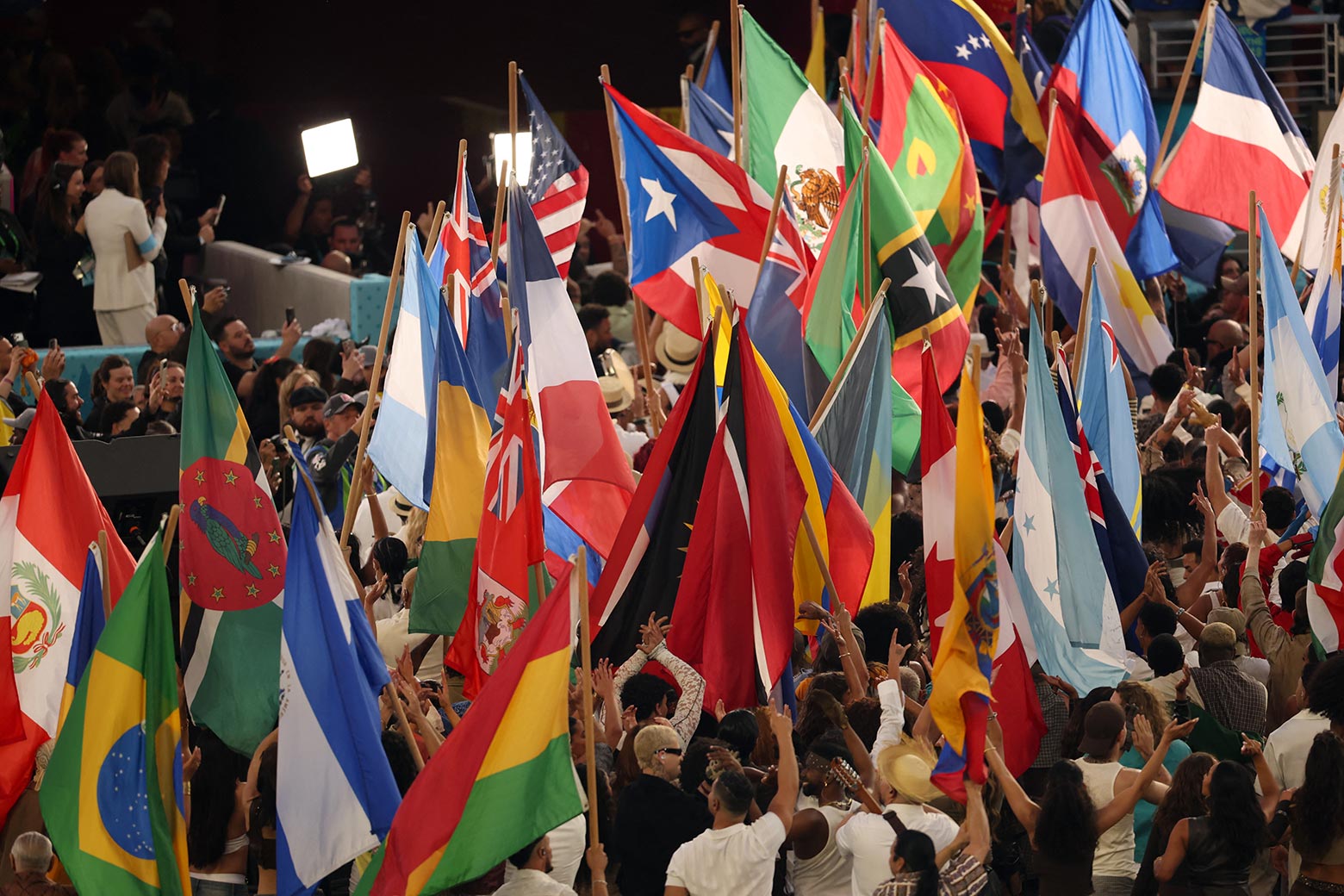 Performers wave the flags of sovereign countries in the Americas at the conclusion of Puerto Rican singer Bad Bunny performance during Super Bowl LX.