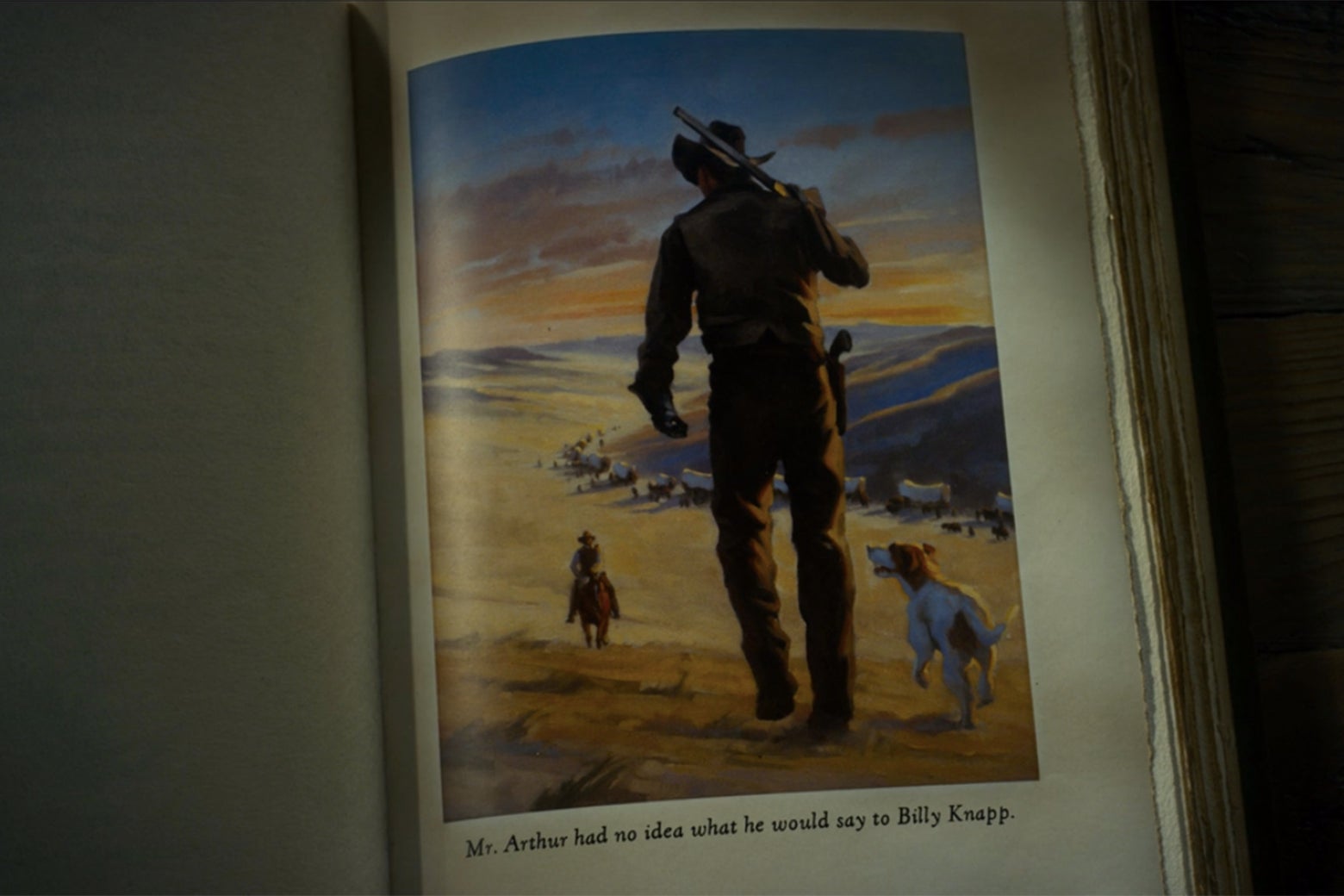 An illustration of a cowboy cresting a hill and walking away from the viewer toward a distant wagon train.