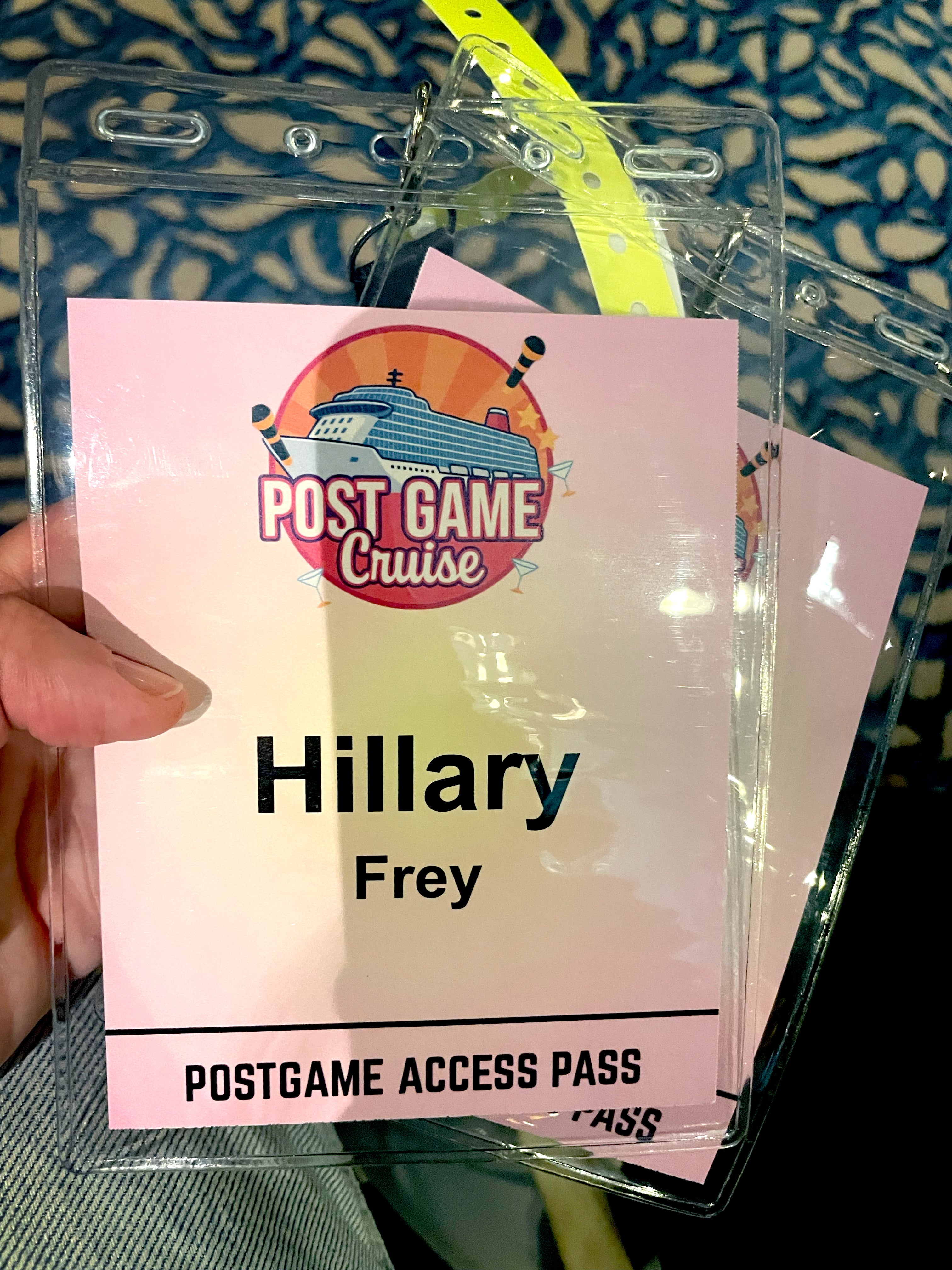 The author holding a pink cruise lanyard, which has her name and the words "Postgame Access Pass."