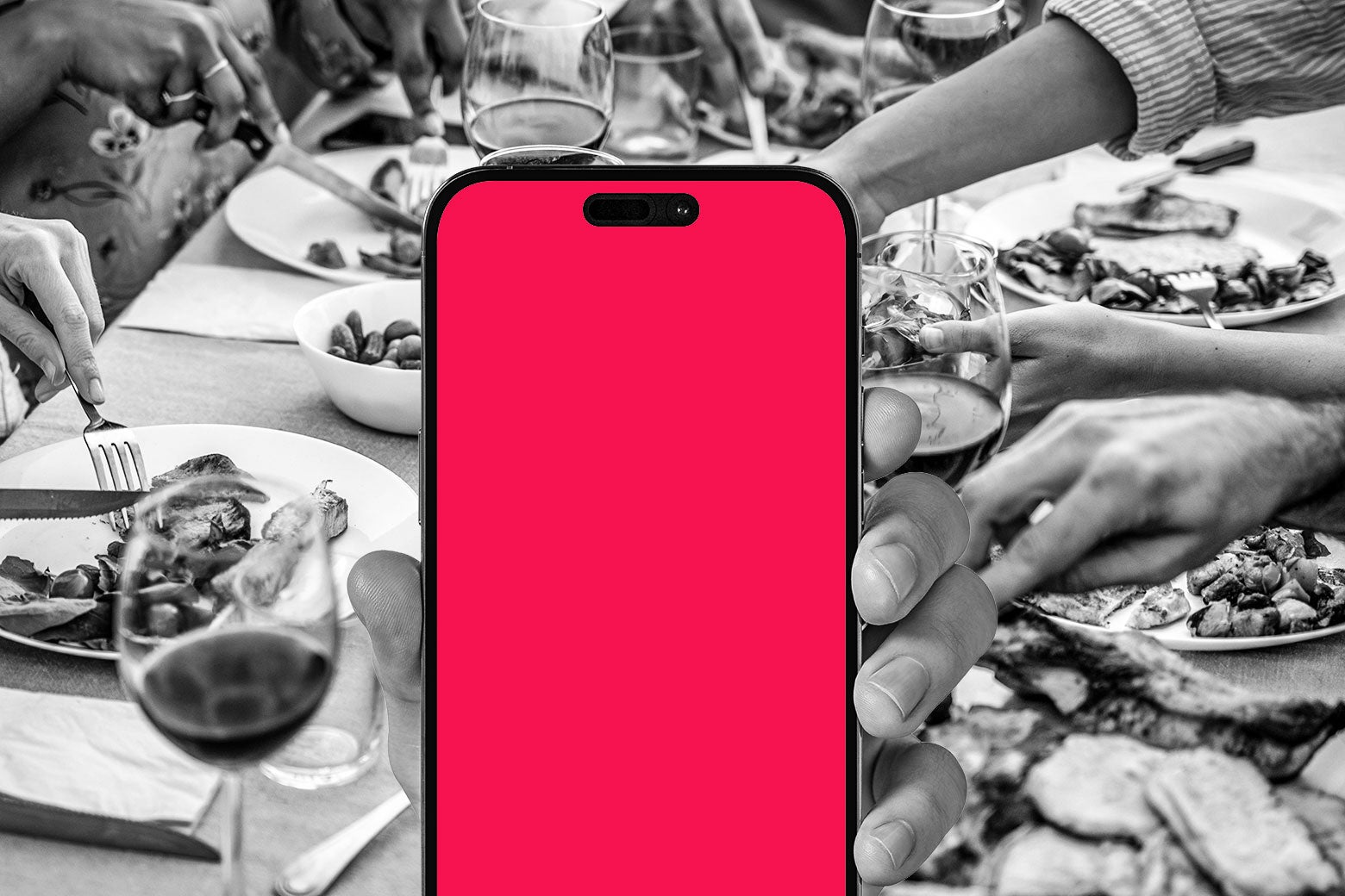 Someone holding up a phone in front of a dinner table.