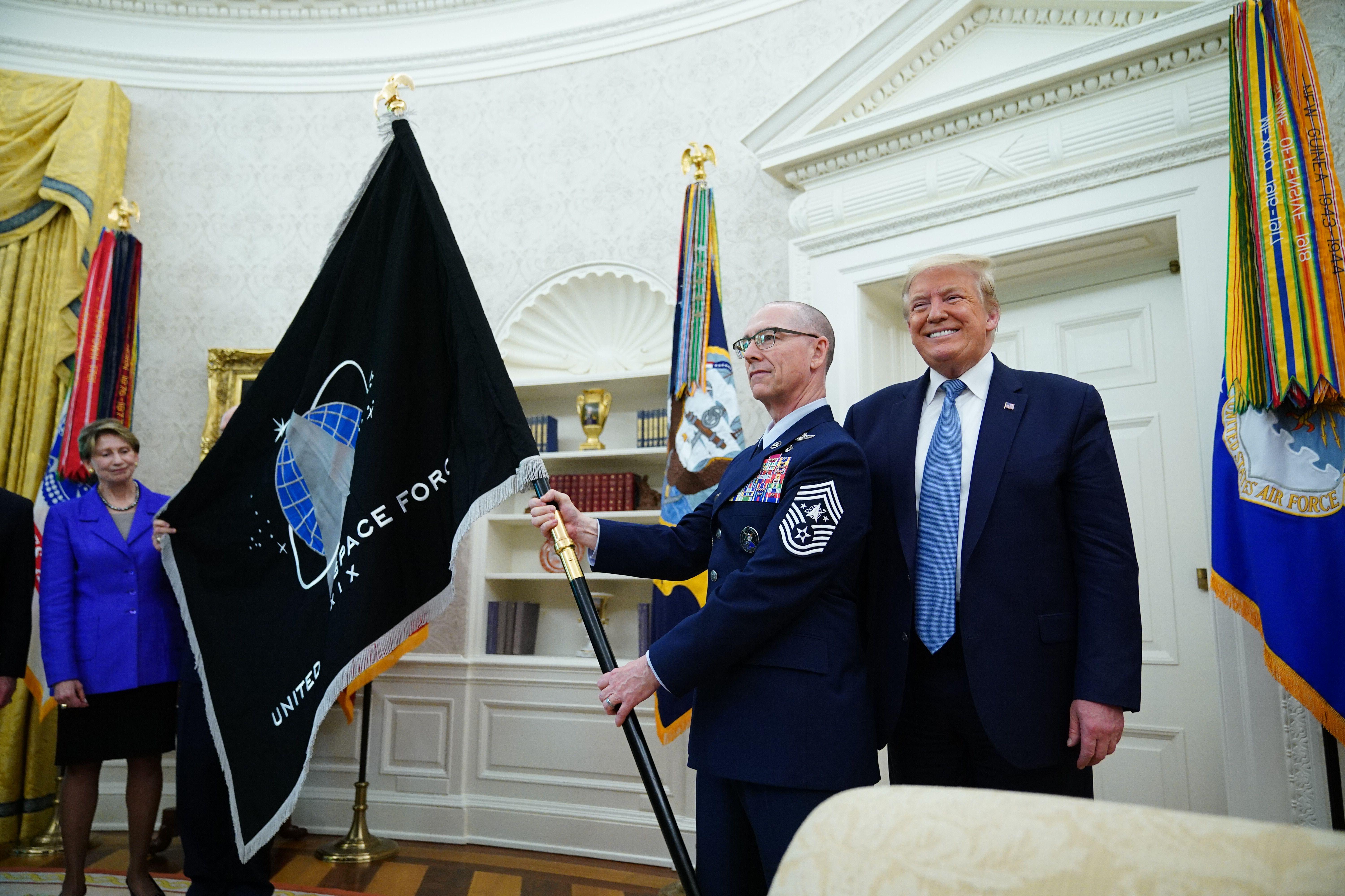 Space Force Senior Enlisted Advisor CMSgt Roger Towberman, with President Donald Trump, presents the Space Force Flag on May 15, 2020, in the Oval Office of the White House.