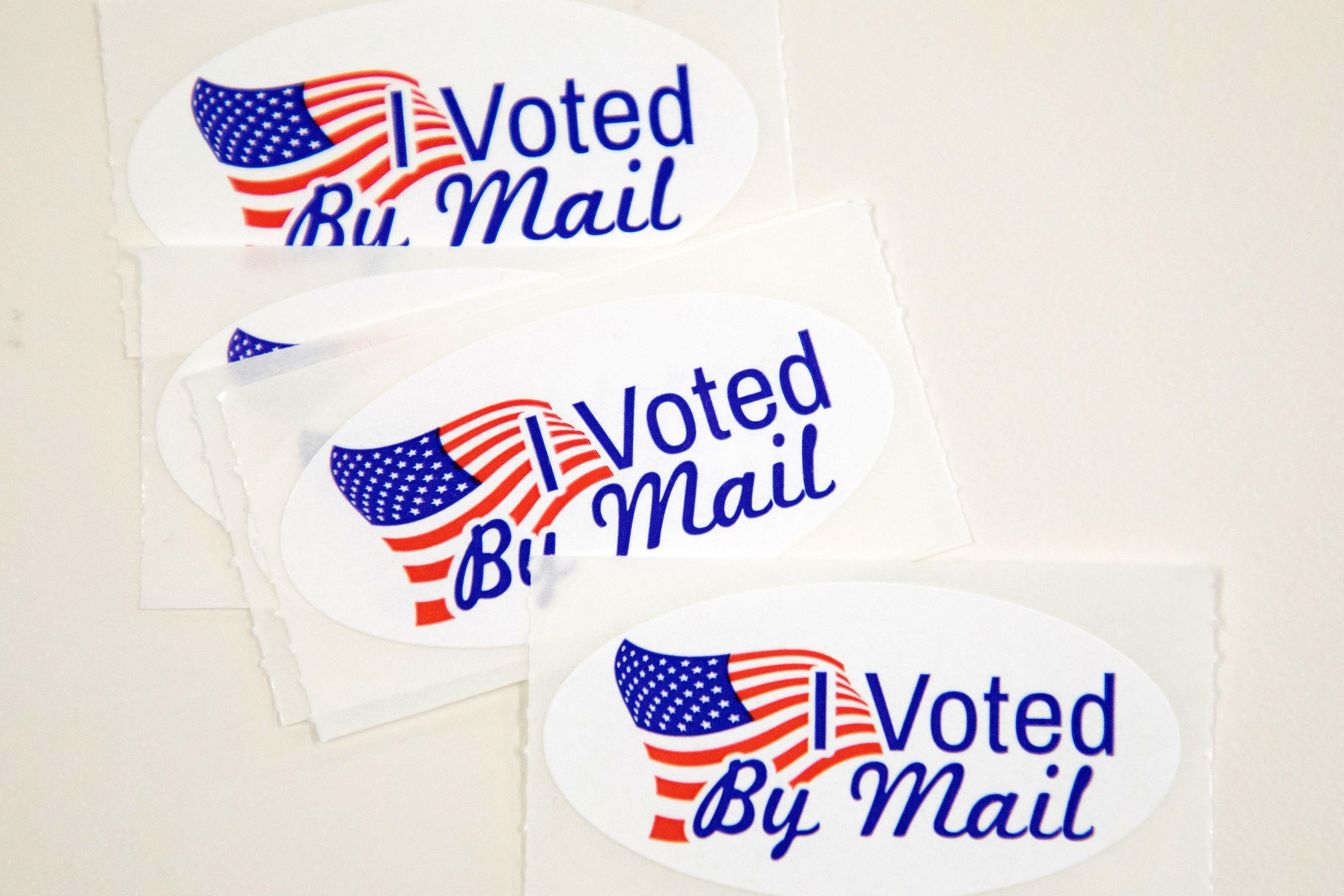 Stickers that read "I Voted By Mail" sit on a table waiting to be stuffed into envelopes by absentee ballot election workers at the Mecklenburg County Board of Elections office in Charlotte, NC on September 4, 2020. 