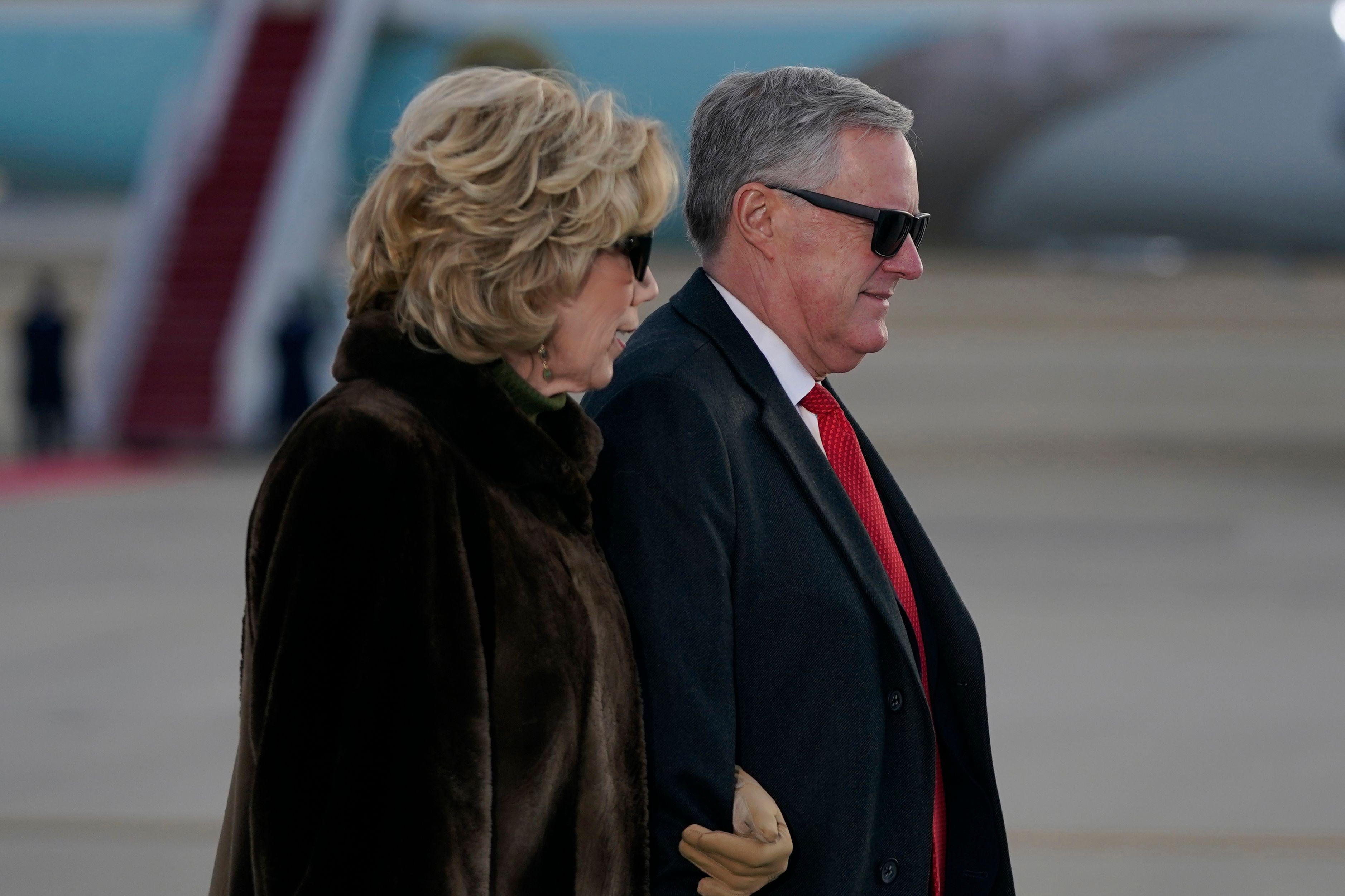 Mark Meadows in a suit and Debbie Meadows in a fur coat, both wearing sunglasses and walking