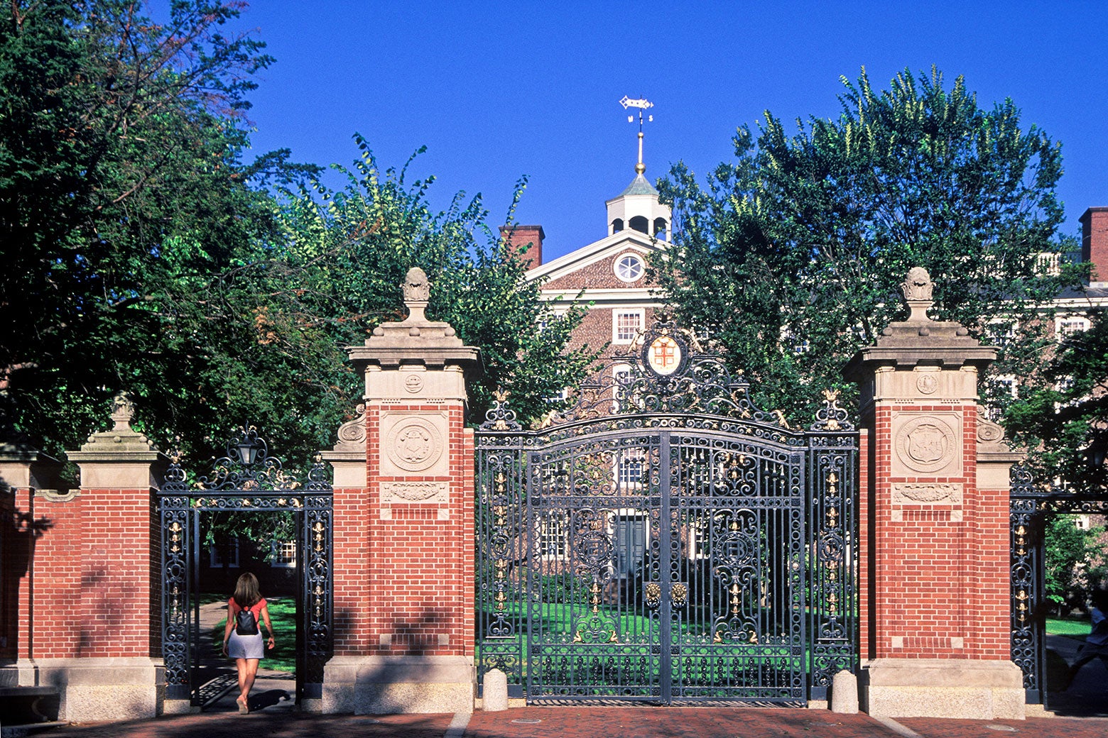 College gates in front of a brick building.