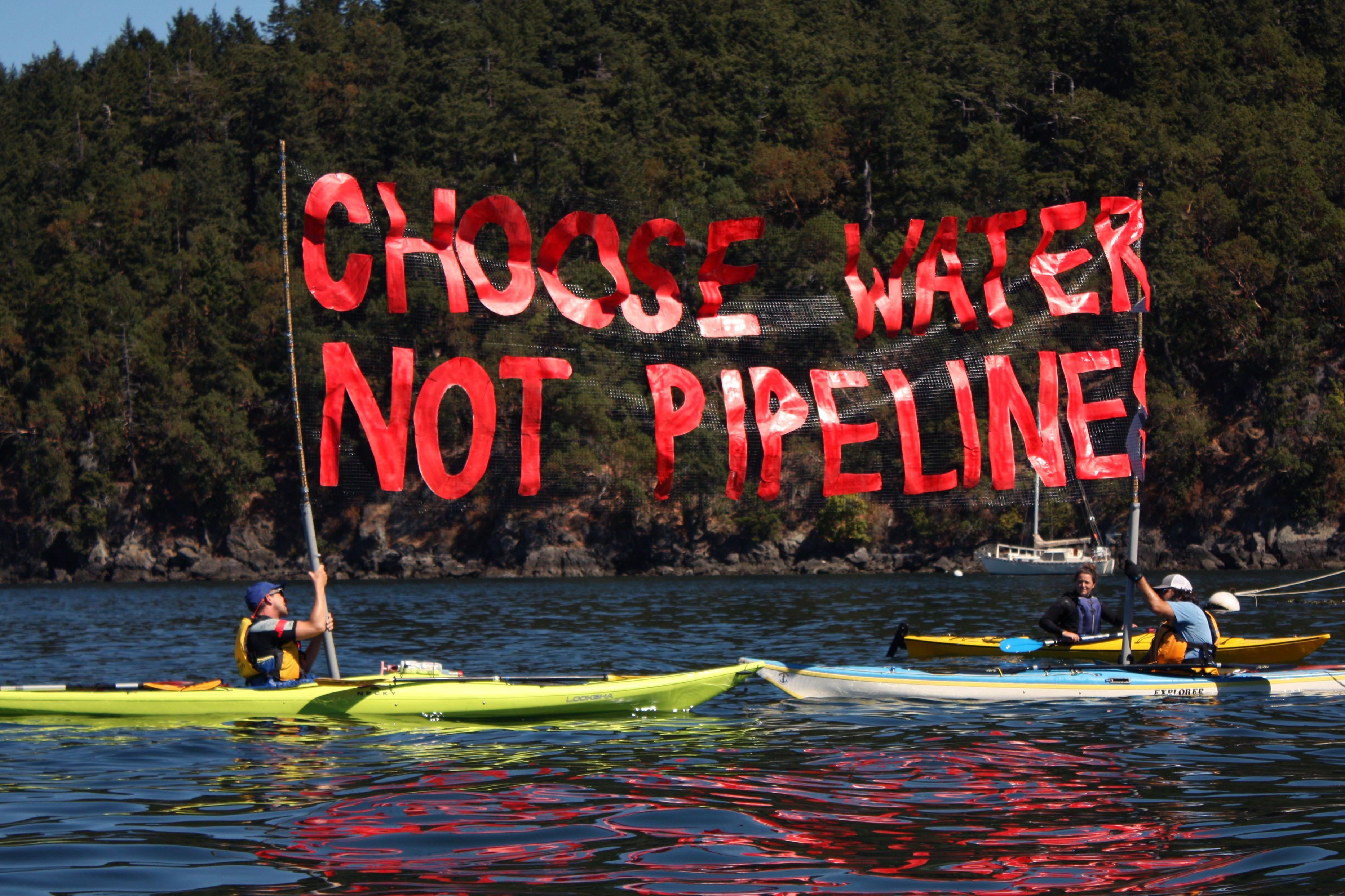 'Kayaktivists', including Greenpeace's Charles Latimer (right) hold up a "Choose Water Not Pipeline" banner during a water-based "pipeline resistance training camp."