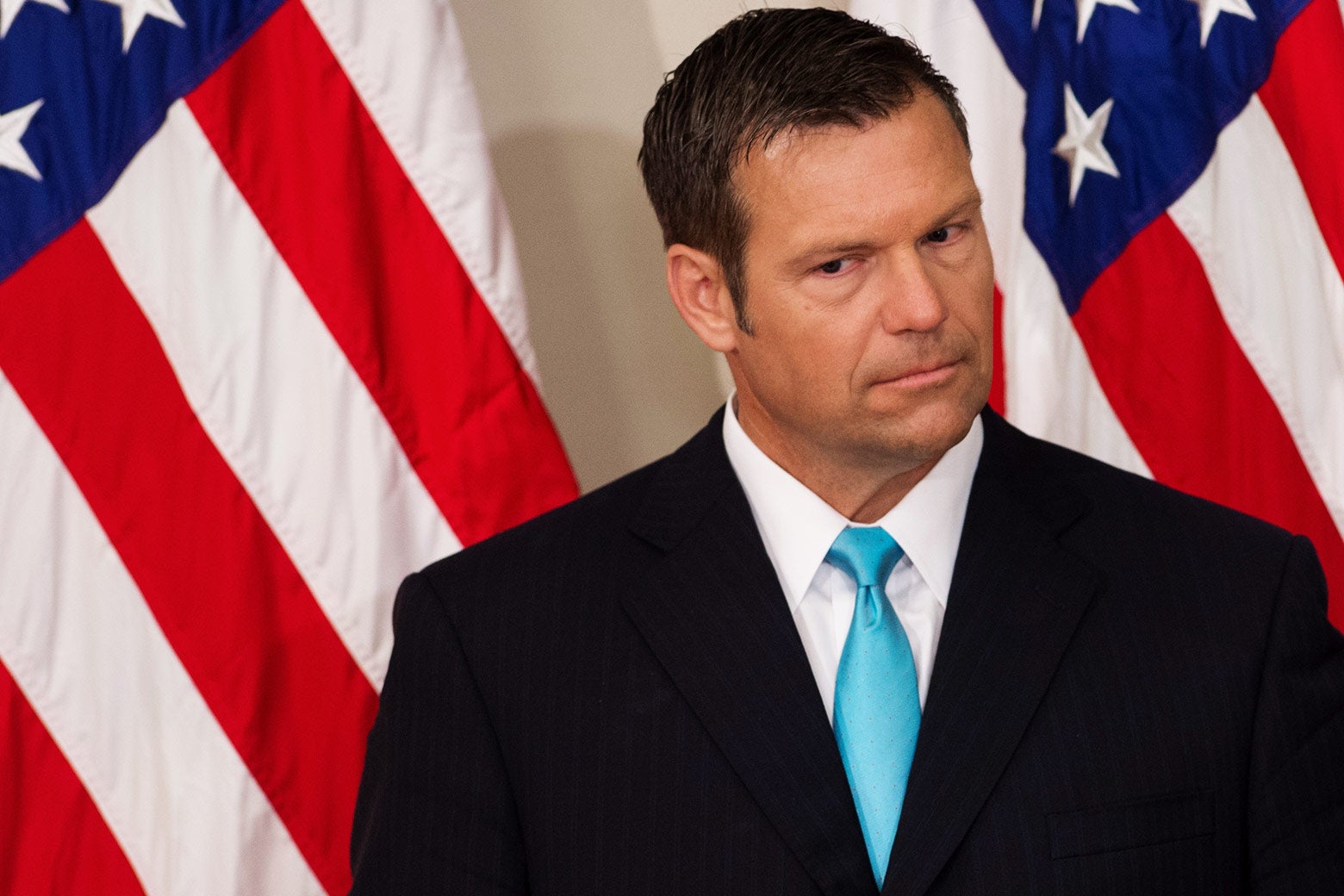 Kansas Secretary of State Kris Kobach listens as President Donald Trump speaks during the first meeting of the Presidential Advisory Commission on Election Integrity in the Eisenhower Executive Office Building next to the White House in Washington on July 19.