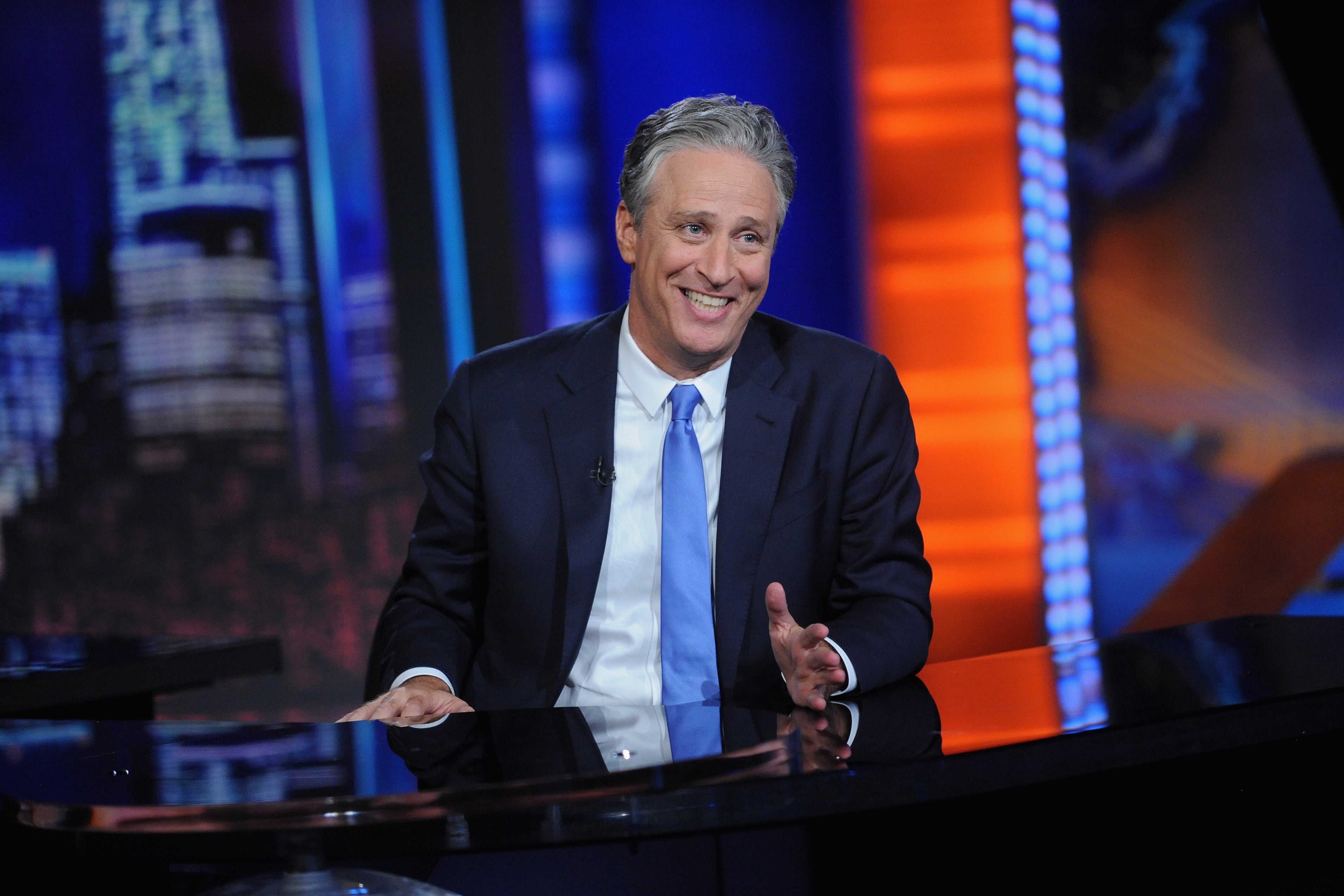 Jon Stewart at the desk of The Daily Show.