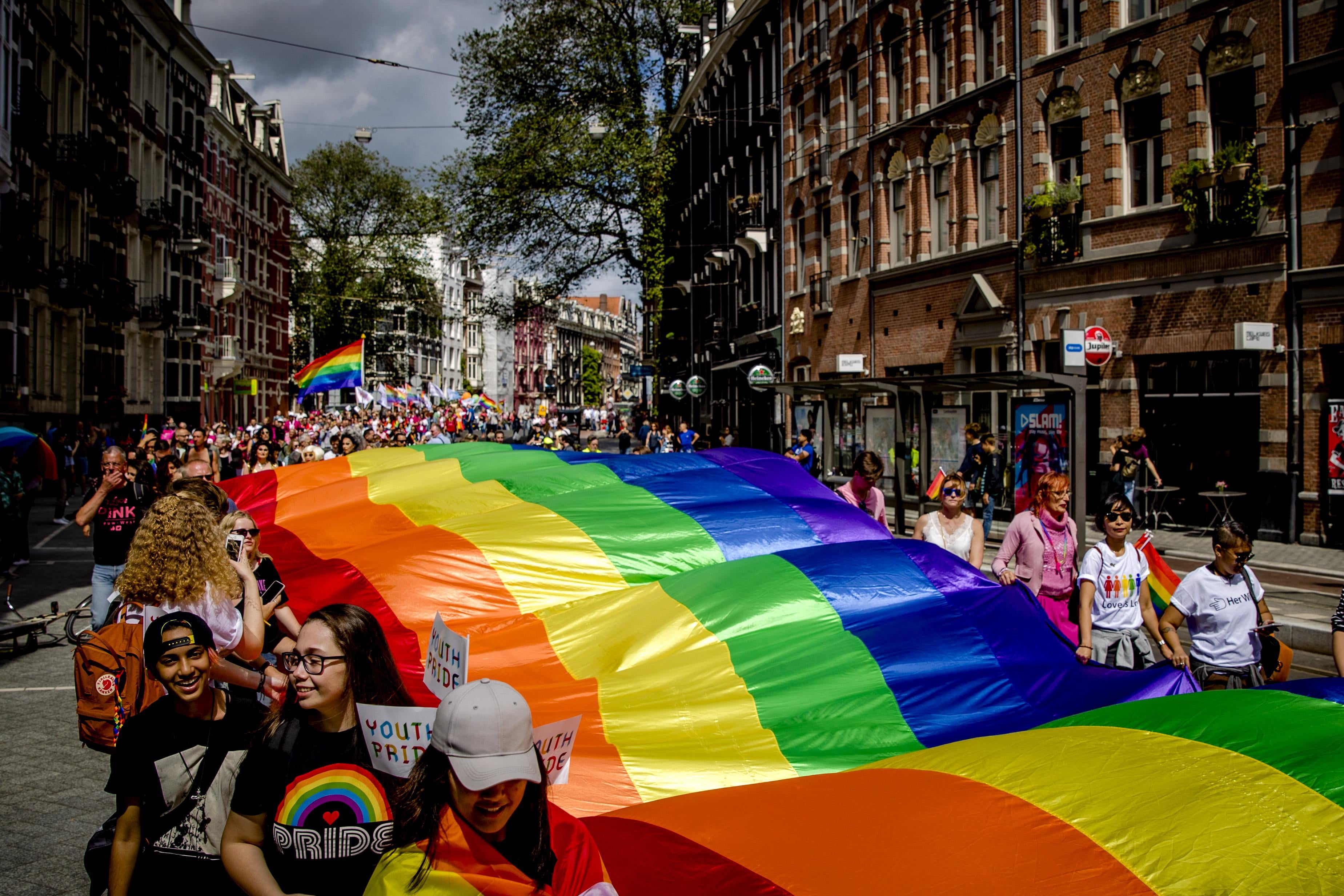 People hold a large rainbow flag during the Pride Walk through the center of Amsterdam on July 29, 2017. 
The march marks the beginning of Pride Amsterdam, a festival to raise awareness of LGBT rights. / AFP PHOTO / ANP / Sander Koning / Netherlands OUT        (Photo credit should read SANDER KONING/AFP/Getty Images)