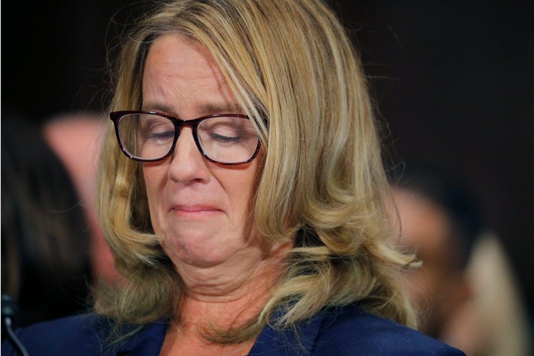 Christine Blasey Ford looks at her hands, sitting in the hearing room.