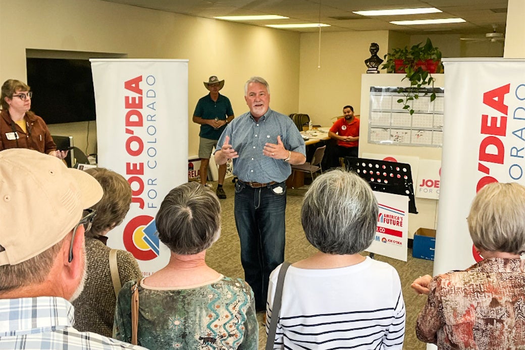 O'Dea talks to a small crowd inside a party office.