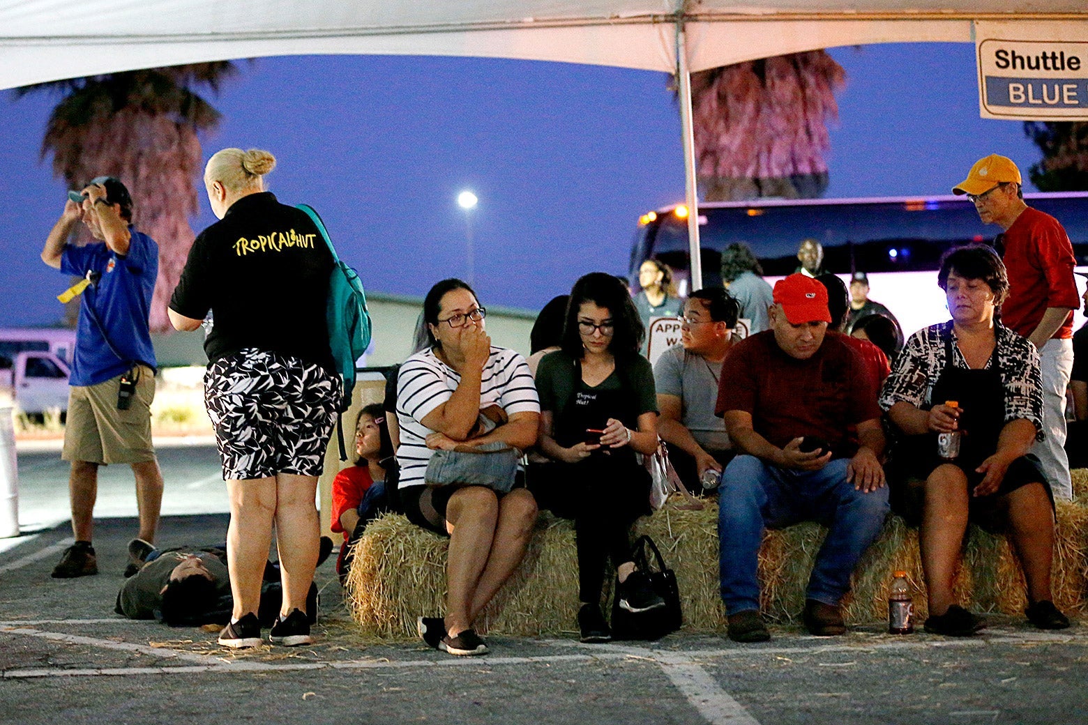 Festival attendees wait for relatives at a reunification center at Gavilan College following a shooting at the Gilroy Garlic Festival on Sunday.