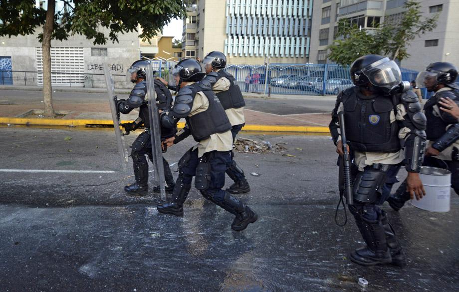 Members of the National Police clash with demonstrators during an anti-government protest, in Caracas on February 19, 2014. 