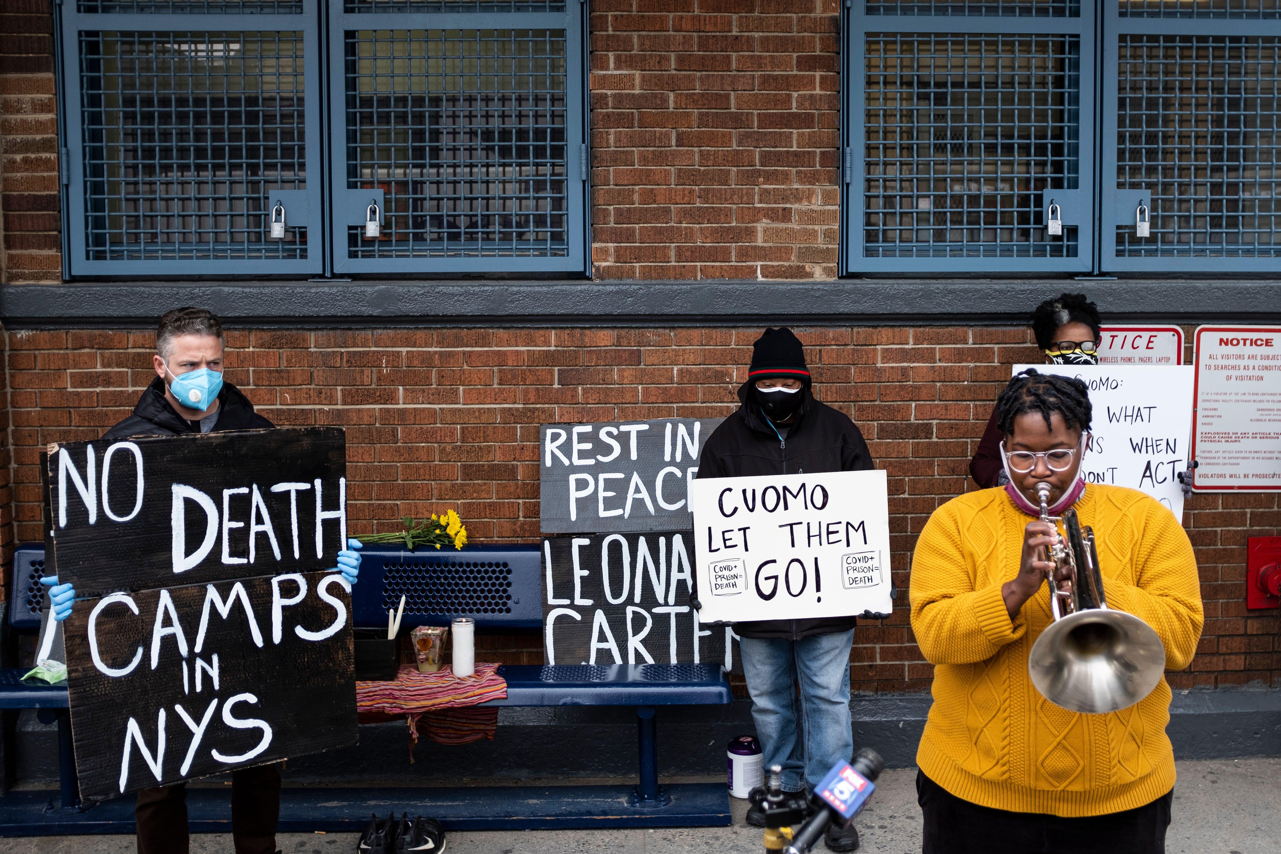 A woman plays a horn while taking part in a vigil outside Queensboro Correctional Facility in New York City. 