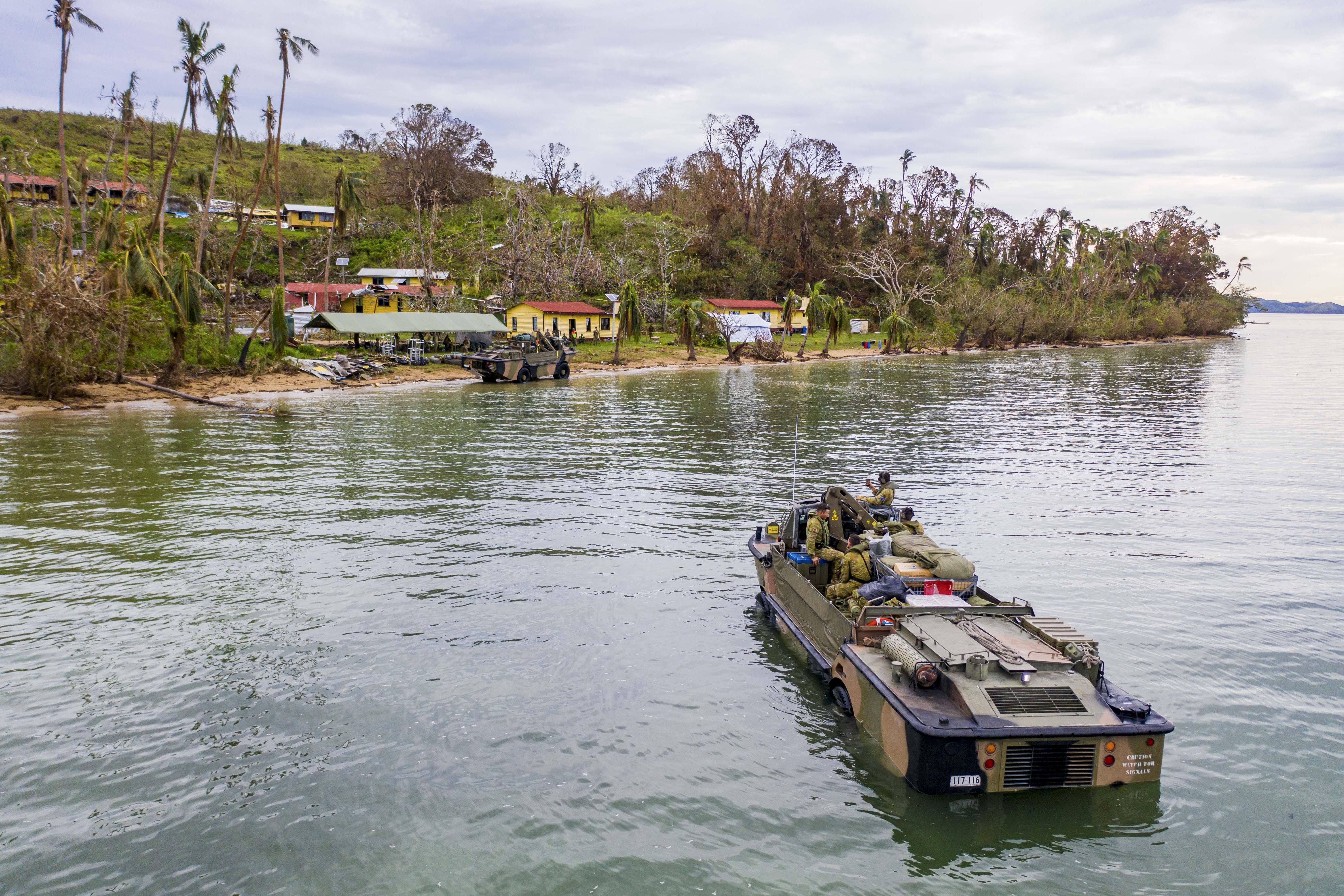 GALOA, FIJI - DECEMBER 30: In this handout provided by the Australian Department of Defence, Australian Army soldiers from the 10th Force Support Battalion drive a Light Amphibious Resupply Cargo 5 onto the island of Galoa, near Vanua Levu, in Fiji to drop off supplies required to repair buildings affected by Cyclone Yasa. On Thursday 24 December 20 over 600 Australian Defence Force (ADF) personnel on HMAS Adelaide deployed to Fiji to assist with the Fijian Government's disaster relief efforts in response to Tropical Cyclone Yasa. ADF elements are working with the Department of Foreign Affairs and Trade (DFAT) to support the RFMF to provide assistance to thousands of Fijians, including many from remote islands whose homes, schools and other local infrastructure were damaged or destroyed by the category 5 cyclone. (Photo by CPL Dustin Anderson/Australian Department of Defence via Getty Images )