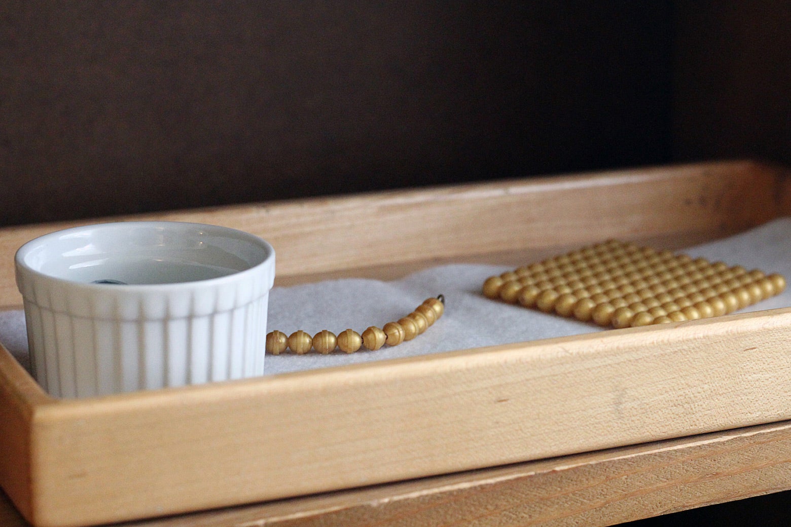 Montessori materials sit on a shelf in a primary classroom at Hill Country Montessori.