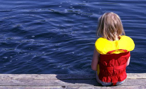Young girl seated on dock.