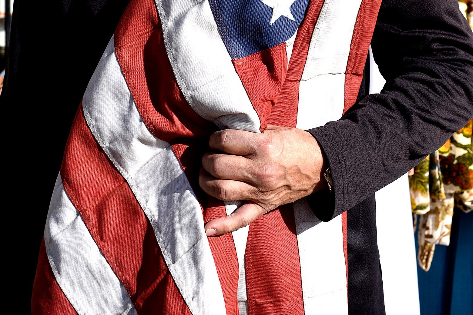 An arm holds a United States flag.