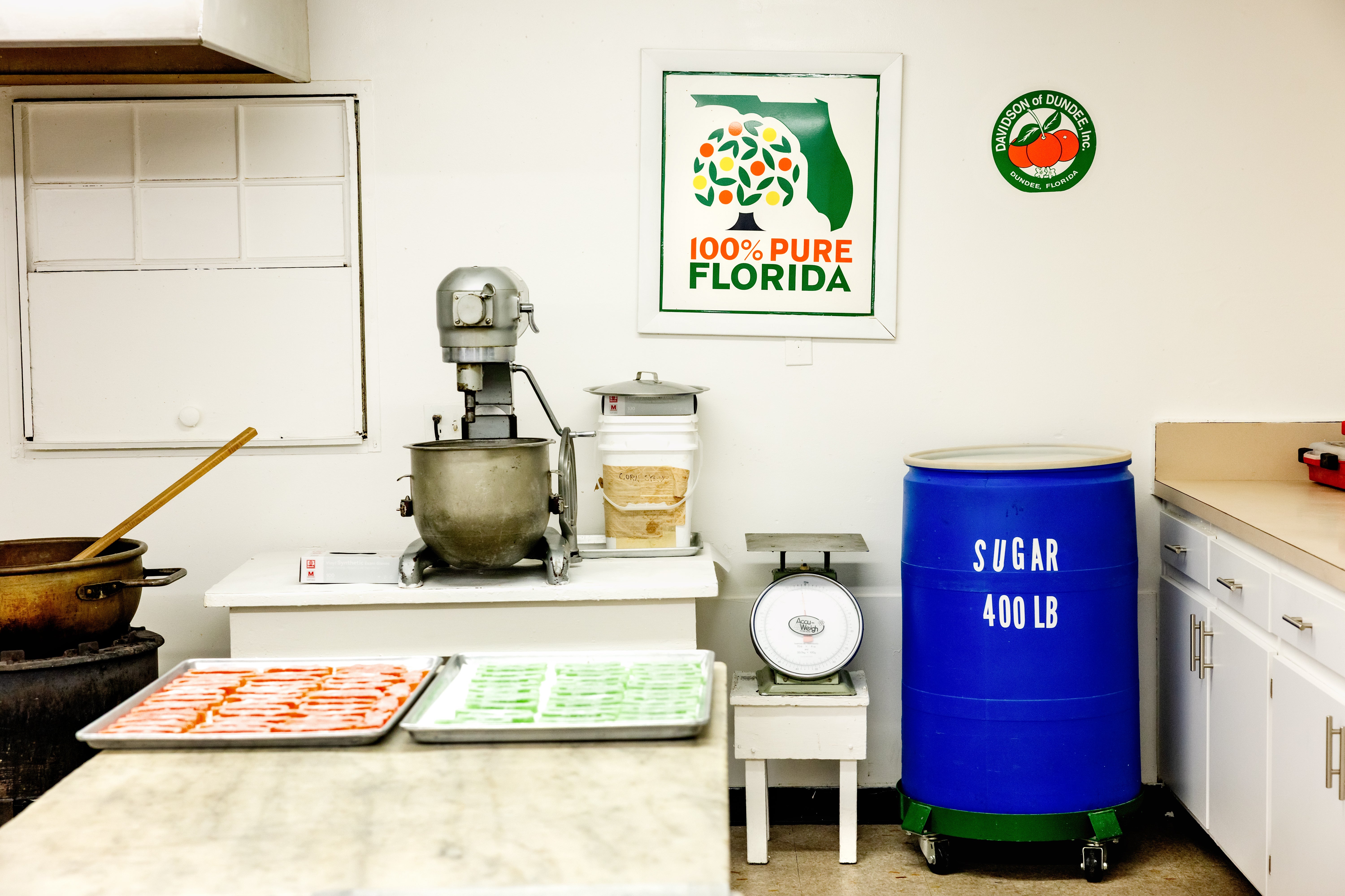 A candy factory with cheerful orange signs on the walls is making only a little bit of candy and seems empty.