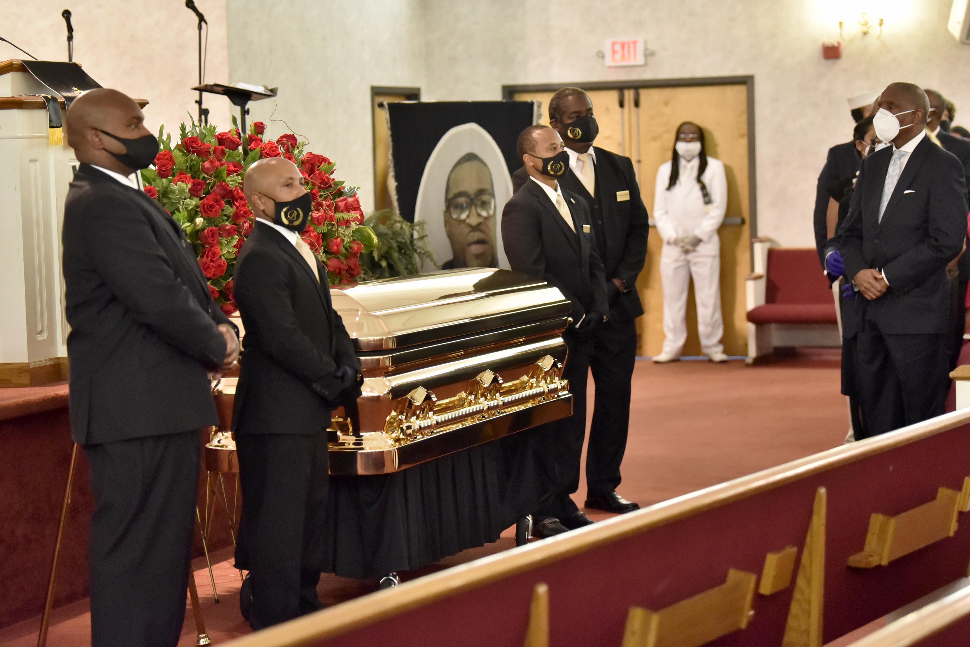 Pallbearers stand next to the remains of George Floyd at the service